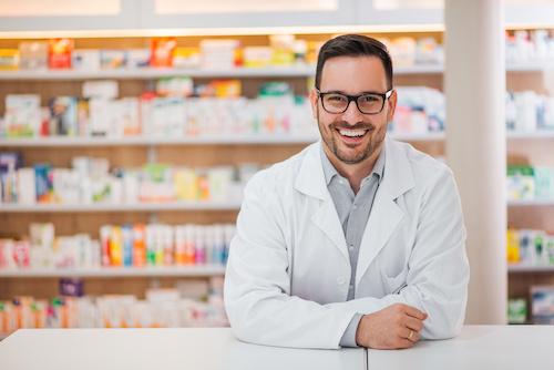 Shown: Smiling portrait of a pharmacist.